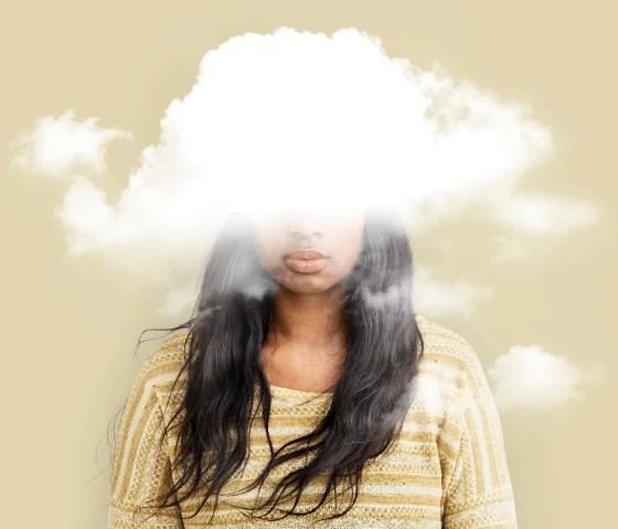 Dette er et bilde av en jente med ansiktet dekket av hvite skyer