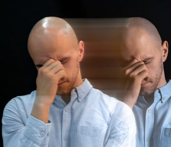 bildet viser en opprørt mann som holder ansiktet i hendene og et splittende bilde av ham