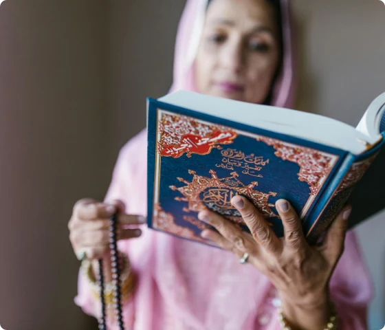 Bildet viser en muslimsk kvinne som leser Koranen og holder en tasbeeh